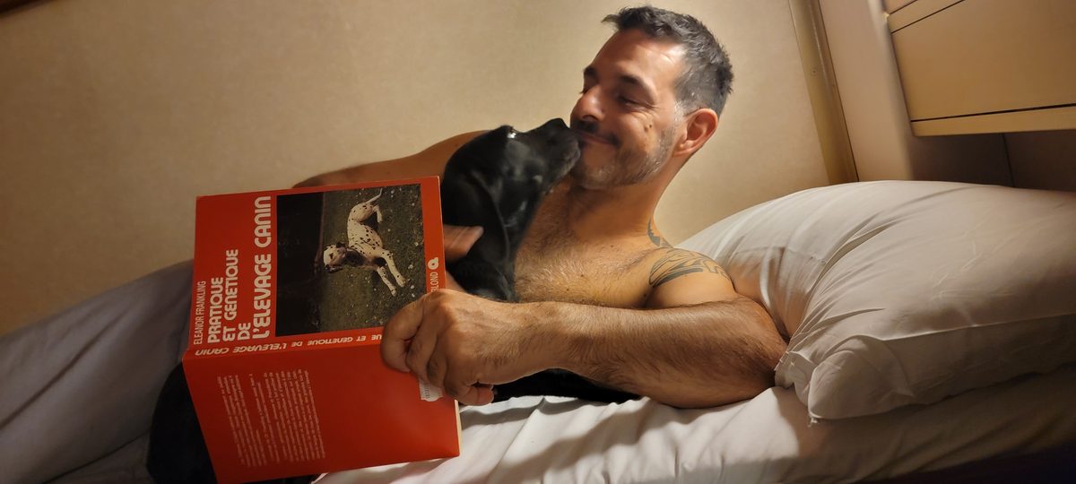 Un câlin avec Berto sur le lit dans la cabine du ferry, avec un livre d’élevage canin